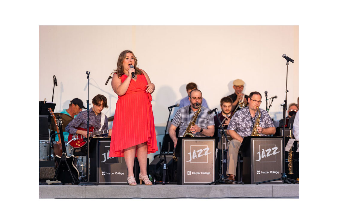 a woman in a red dress sings with the jazz ensemble