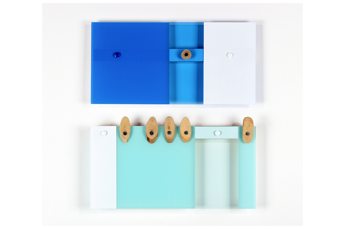 Sheets of acrylic in blues and whites joined with fasteners and decorated with plain wood shapes fastened with metal.  Piece is displayed in two halves.