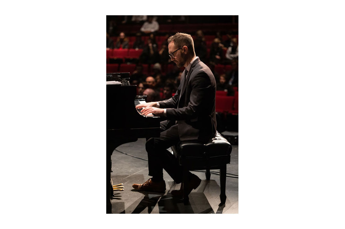 a man plays the piano at a concert