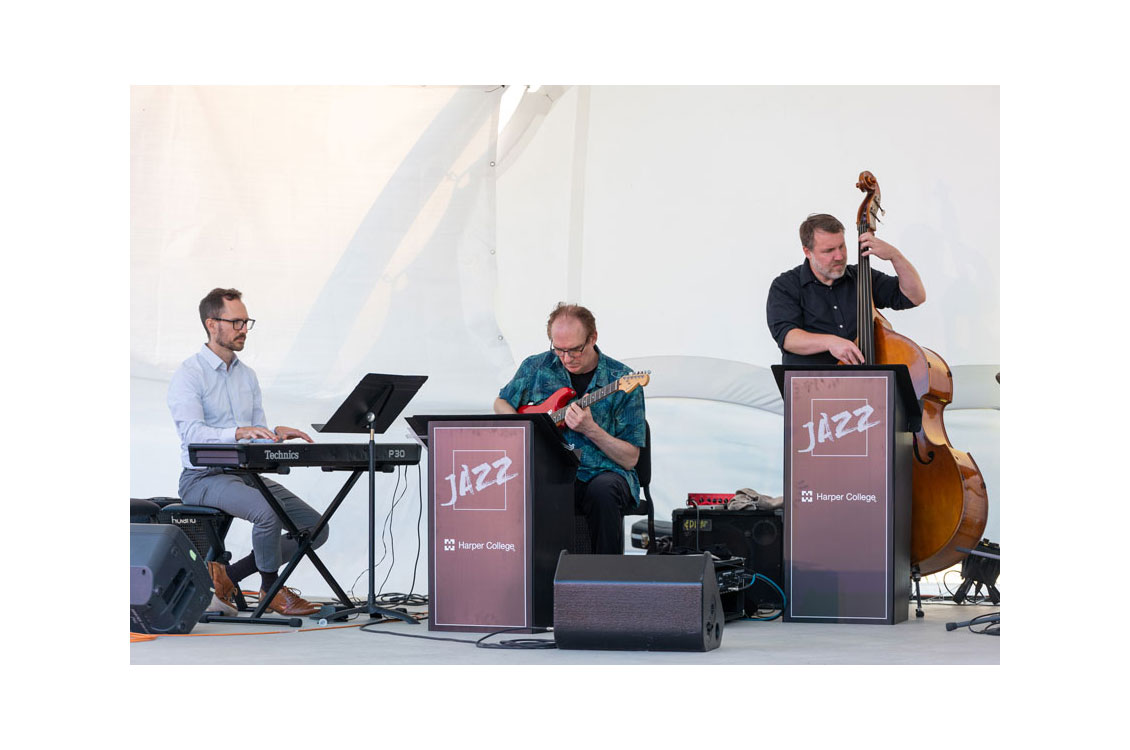 three jazz musicians perform on stage
